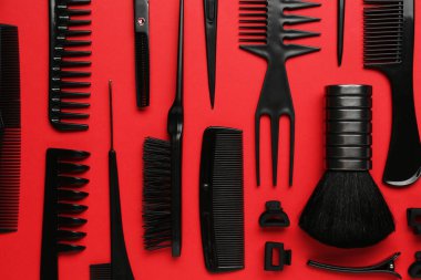 Kırmızı arka planda farklı kuaför aletleri, düz yatıyordu