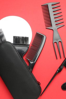 Kırmızı arka planda farklı kuaför aletleri, düz yatıyordu