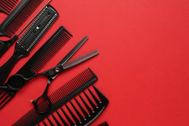 Kırmızı arka planda farklı kuaför aletleri var. Metin için boşluk