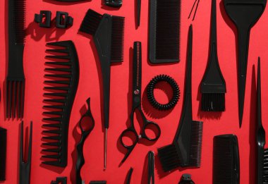 Kırmızı arka planda farklı kuaför aletleri, düz yatıyordu