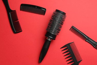 Kırmızı arka planda farklı kuaför aletleri, düz yatıyordu