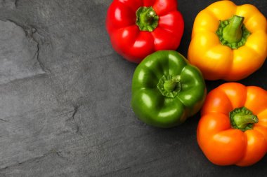 Taze renkli dolmalık biberler siyah desenli masada, düz yerde. Metin için boşluk