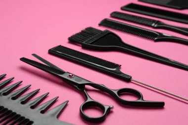 Pembe arka planda farklı kuaför araçları, yakın plan