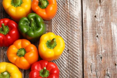 Tahta masada taze, renkli dolmalık biberler, düz uzanmış. Metin için boşluk