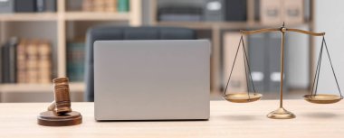 Yargıç tokmağı, terazi ve dizüstü bilgisayarı ofisteki ahşap masada.