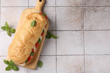 Mozarella peynirli, domatesli, fesleğenli, kiremitli, düz bir masa. Metin için boşluk