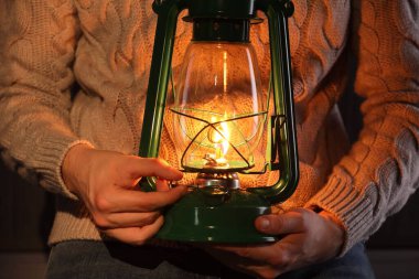 Ahşap arka planda klasik gaz lambası olan adam, yakın plan.