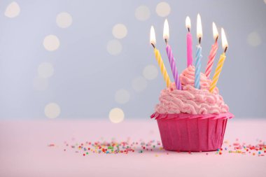 Kekin içinde mum yakmak ve bulanık ışıklara karşı masaya serpiştirmek. Metin için boşluk