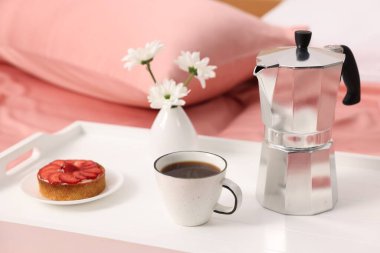 Nefis bir kahvaltı tepsisi ve çiçeklerle kapalı bir yerde, yakın plan.