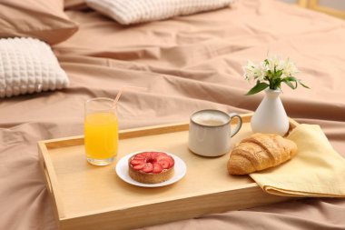 Nefis kahvaltı tepsisi ve yatağın içinde çiçekler. Metin için boşluk