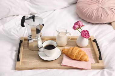 Nefis bir kahvaltı tepsisi ve çiçeklerle kapalı bir yerde, yakın plan.