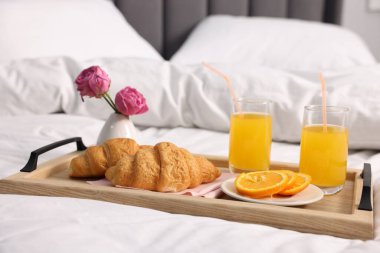 Nefis bir kahvaltı tepsisi ve çiçeklerle kapalı bir yerde, yakın plan.