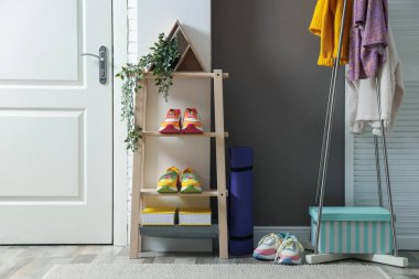 Koridorda farklı ayakkabı, giysi ve aksesuarlar var.