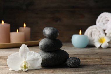 Tahta masanın üzerinde spa taşları olan kompozisyon, yakın plan.