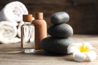 Kozmetik ürünleri ve spa taşlarıyla ahşap masaya yakın plan kompozisyon.