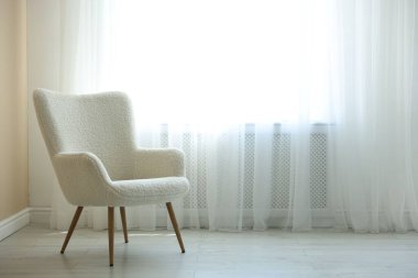 Pencerenin yanındaki rahat beyaz koltuk, metin için boşluk