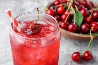 Buzlu vişneli gazoz ve gri desenli masada böğürtlen, yakın plan.