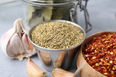 Gri masada farklı aromatik baharatlar, yakın plan.