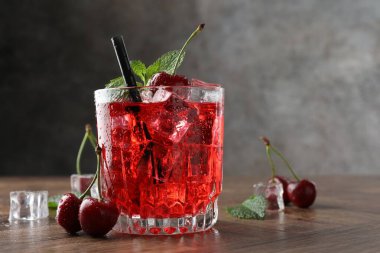 Buzlu vişneli gazoz, böğürtlen ve nane şekerli ahşap masa, yakın plan. Metin için boşluk