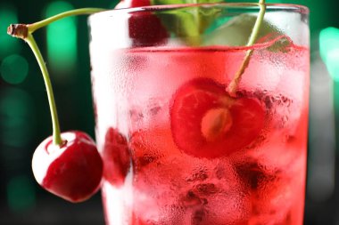 Buzlu vişneli soda, böğürtlen ve nane şekerli bulanık yeşil arka plan, yakın plan.