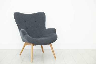 Beyaz duvarın yanında rahat bir koltuk, metin için boşluk.