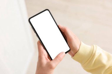 Evde modern akıllı telefon kullanan bir kadın, yakın plan.