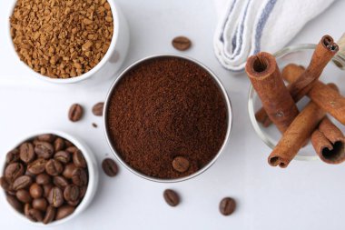 Farklı türde kahve, fasulye ve tarçın çubukları ışık masasında, düz yerde