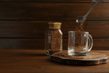 Tahta masaya granüle edilmiş hazır kahveyi koymak, yakın plan. Metin için boşluk