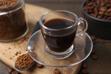 Aromatik sıcak içecek, hazır kahve ve fasulye ahşap masada, yakın plan.