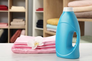 Kumaş yumuşatıcı ve katlanmış giysiler dolap odasındaki masanın üzerinde.