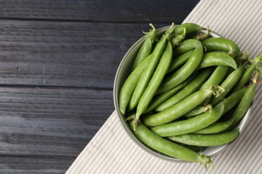 Siyah ahşap masada taze taze taze bezelyeler, üst manzara. Metin için boşluk