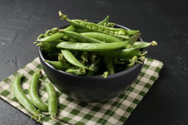Taze taze bezelyeler siyah masada, yakın plan.
