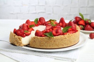 Çilekli nefis peynirli kek ve beyaz masada nane şekeri, yakın plan.