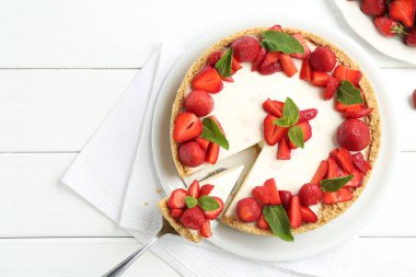 Çilekli nefis bir cheesecake ve beyaz ahşap masada nane şekeri. Metin için boşluk