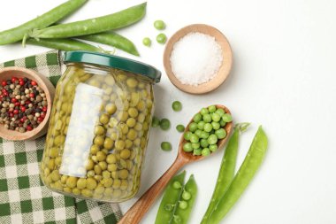 Kavanozda bezelye turşusu ve beyaz masada malzemeler. Metin için boşluk