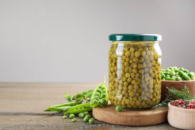 Kavanozda bezelye turşusu, baharatlar, ahşap masada dereotlar ve kabuklar, yakın plan. Metin için boşluk