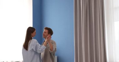 Genç çift evde dans ediyor, kamera aşağı iniyor.