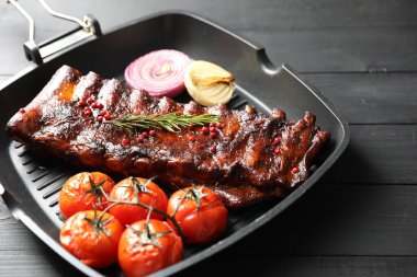 Biberiyeli domuz pirzolası, domates ve soğan. Gri ahşap masada, yakın plan.