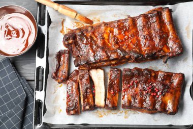 Lezzetli kaburgalar, sos ve fırça gri ahşap masa, düz uzanmış