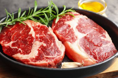 Yemek masasında çiğ et ve baharat parçaları, yakın plan.