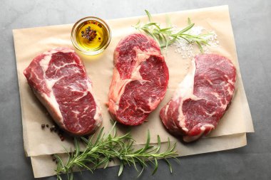 Çiğ et parçaları ve baharatlar gri masada, düz yatıyordu.