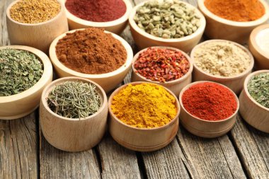 Tahta masadaki kaselerde farklı aromatik baharatlar, yakın plan.