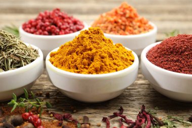 Ahşap masada farklı aromatik baharatlar, yakın plan.