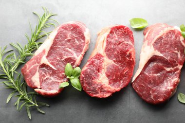 Çiğ et parçaları ve baharatlar gri masada, düz yatıyordu.