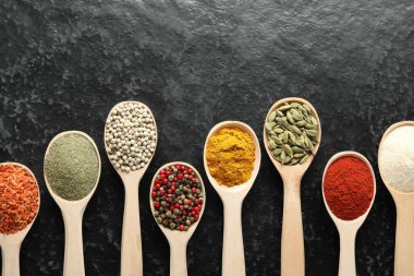 Siyah masadaki kaşıklarda bir sürü farklı baharat var. Metin için boşluk