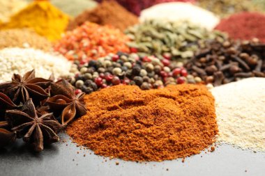 Gri masada farklı aromatik baharatlar, yakın plan.