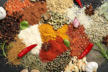 Gri masada farklı aromatik baharatlar, üst görünüm.