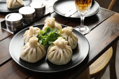 Nefis khinkali kişniş ve şarapla servis edilir ahşap masada, yakın plan.