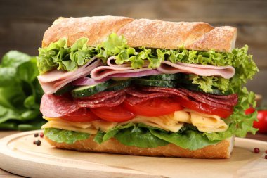 Tahta masada jambonlu ve sebzeli baget sandviç, yakın plan.