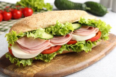 Jambonlu ve sebzeli baget sandviç açık gri masada, yakın plan.